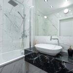 Luxurious bathroom featuring marble walls, a vessel sink, and contemporary fixtures.